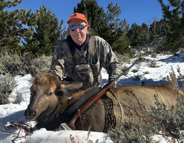 A nonresident hunter posing with his cow elk